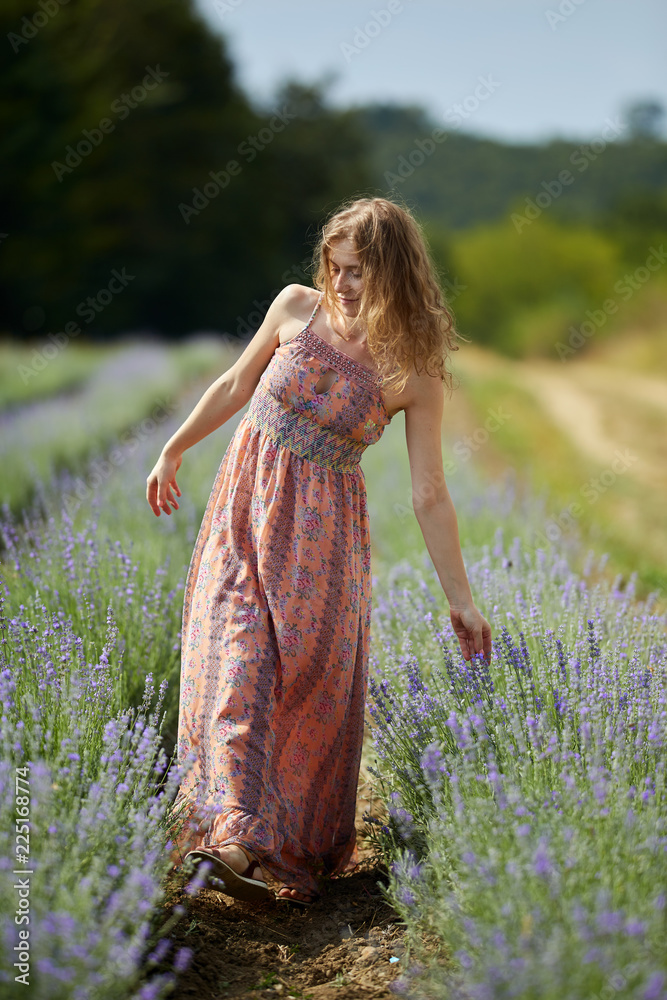 Obraz premium Farmer lady in floral dress in lavender field