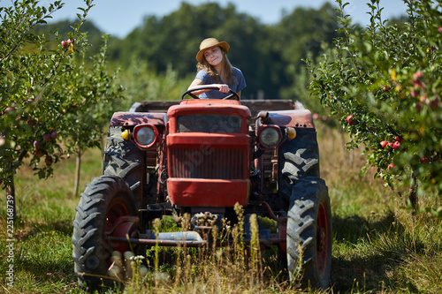 Young farmer woman driving her old tractor