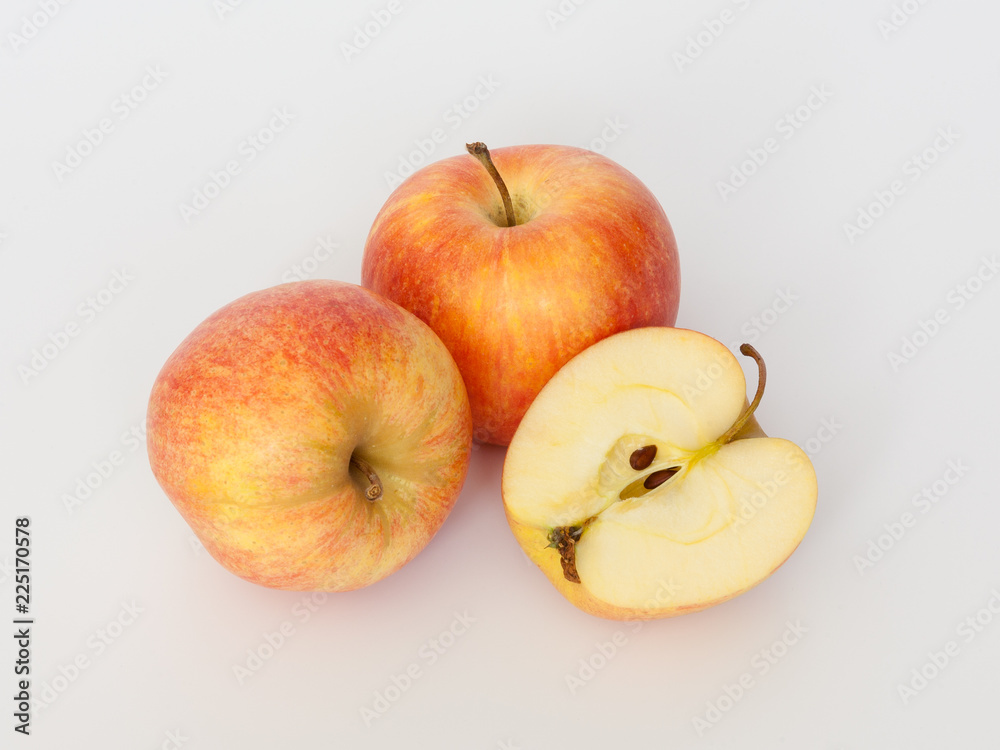 Red and yellow apples on white background. One cut in half. Isolated. Red and yellow apples on white background. One cut in half. Isolated.