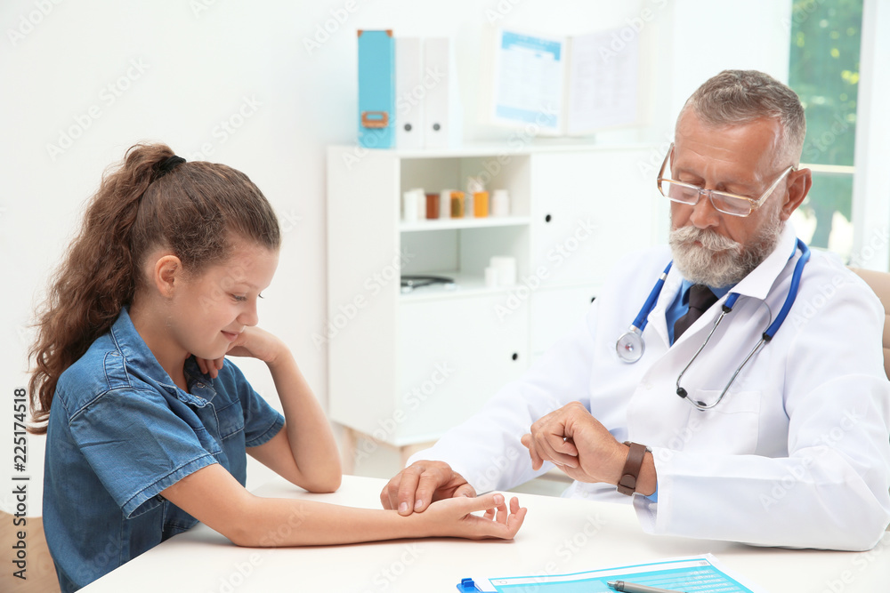 Doctor checking little girl's pulse in hospital Doctor checking little girl's pulse in hospital