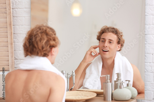 Fototapeta Naklejka Na Ścianę i Meble -  Young man looking in mirror after shaving at home
