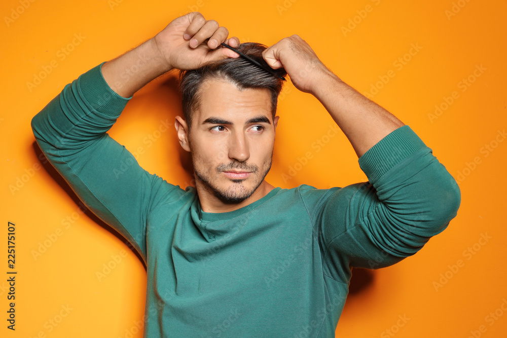 Young man with comb posing on color background. Trendy hairstyle Young man with comb posing on color background. Trendy hairstyle