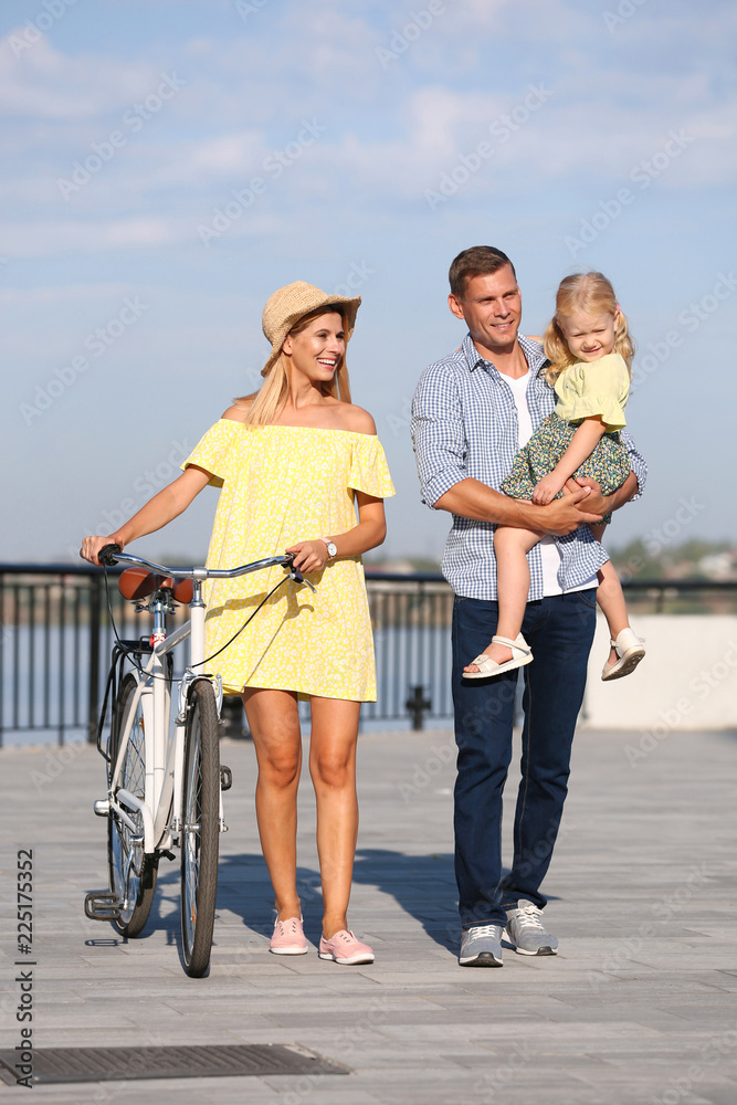 Happy family with bicycle outdoors on sunny day Happy family with bicycle outdoors on sunny day
