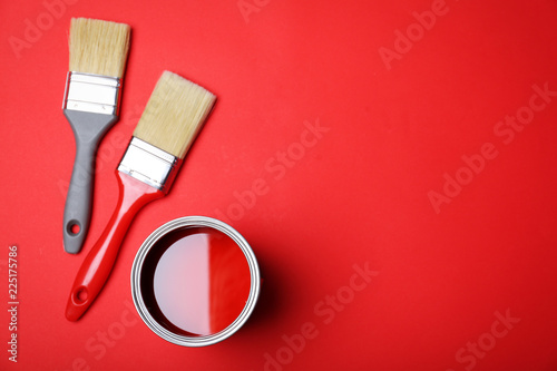 Fototapeta Naklejka Na Ścianę i Meble -  Flat lay composition with paint can and brushes on red background. Space for text