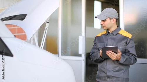 Mechanic using a tablet with a truck in the background