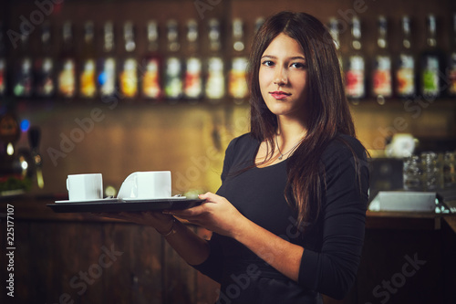 Waiters carrying plates with food, in a restaurant.