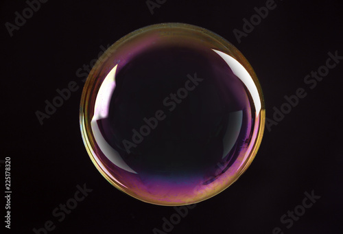 Beautiful translucent soap bubble on dark background photo