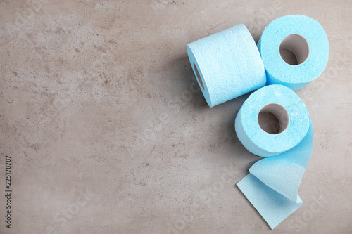 Toilet paper rolls on grey background, top view. Space for text