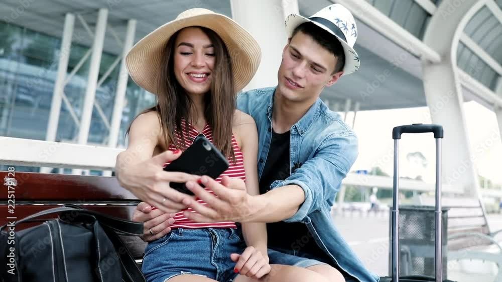 Couple Traveling, Making Photo On Phone Near Airport Couple Traveling, Making Photo On Phone Near Airport