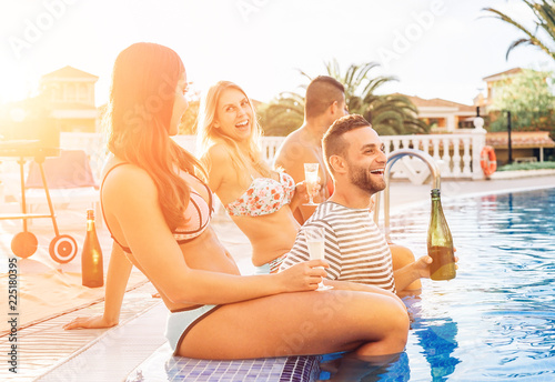 Canvas Print Group of happy friends making a pool party at sunset - Young people laughing and