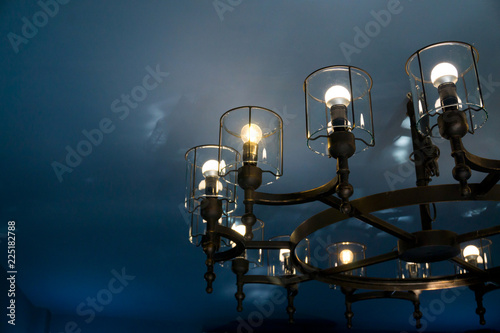 Vintage light classic chandelier hanging on the blue ceiling