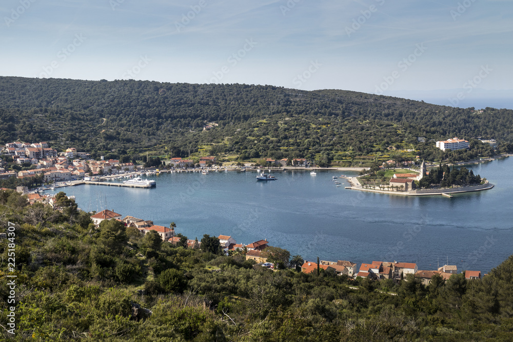 Ancient stone houses in town Vis surrounded with green nature and blue sea, on island Vis in Croatia