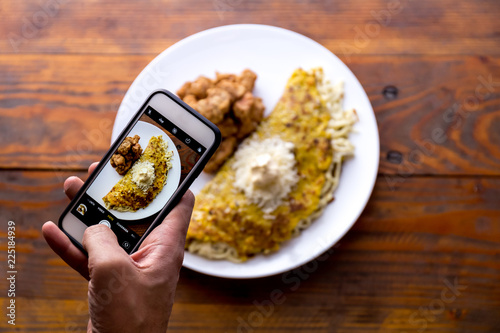 Men hands taking food photo of VENEZUELAN CACHAPA by mobile phone photo