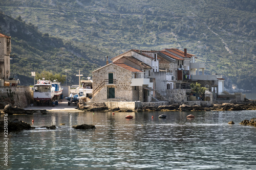 Fisherman's boats and old stone houses in port of Komiza on island Vis in Croatia