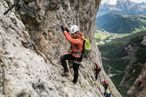 four mountain climbers on a Via Ferrata in the Dolomites in Alta Badia photo