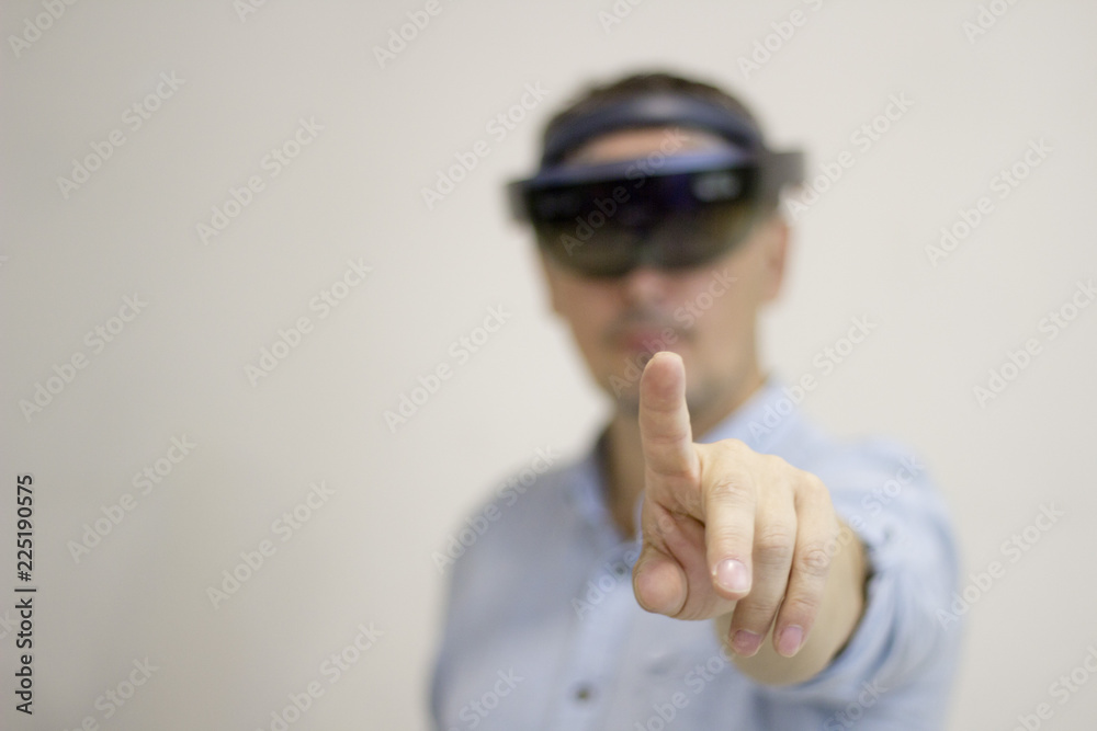 A man-businessman with a virtual reality headset controls his hand. Future technology. A man-businessman with a virtual reality headset controls his hand. Future technology.