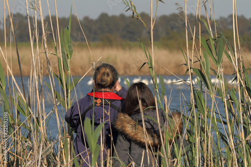 Mother and daughter observing birds in the field
