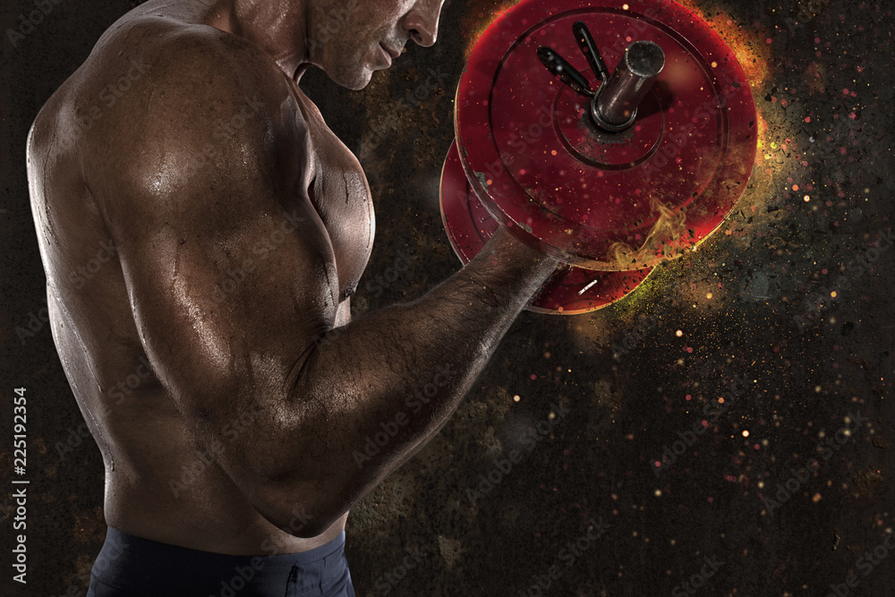 Fototapeta Lekkoatletycznego mężczyzna trening biceps na siłowni z efektem ognia