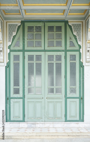 vintage door. A exterior details of traditional Thai vintage door in green color.