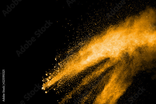 Orange color powder explosion on black background.