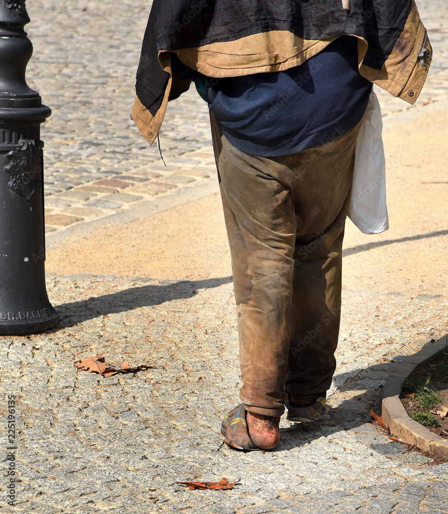 Obdachloser mit nackten Füßen in kaputten Schuhen Stock Photo | Adobe Stock