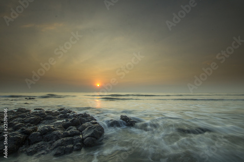 Glorious morning sunrise at Pantai Batu Hitam (Batu Hitam Beach), Kuantan, Pahang. Awesome clouds with ray of light visible.