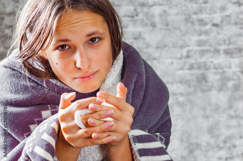 portrait of young teenager brunette girl with long hair holding a cup in hands on gray wall background portrait of young teenager brunette girl with long hair holding a cup in hands on gray wall background