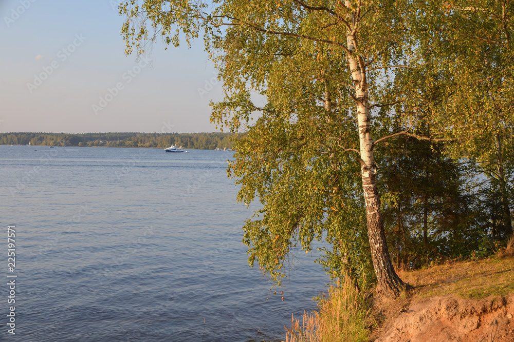 Autumn lake, yellowed lake against a lake with a yacht Autumn lake, yellowed lake against a lake with a yacht