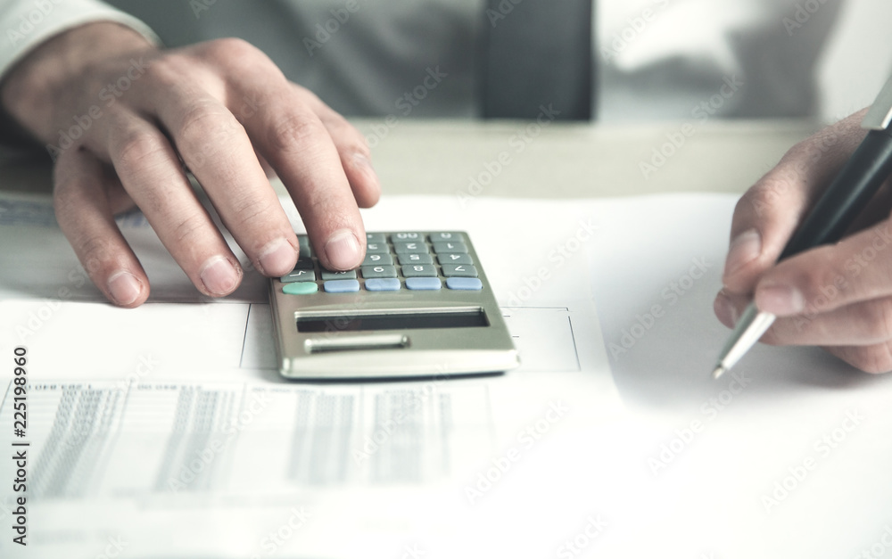 Businessman using calculator in his desk. Businessman using calculator in his desk.