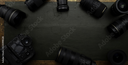 Top down view of vintage table with camera gear around it. Photography background banner.
