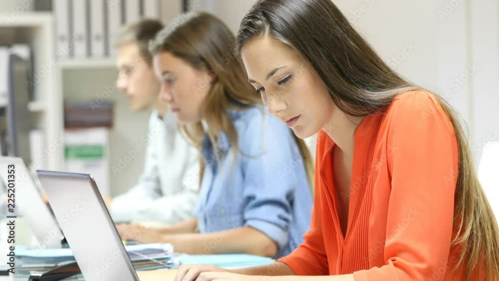 Side view of three office workers working online with laptops Side view of three office workers working online with laptops