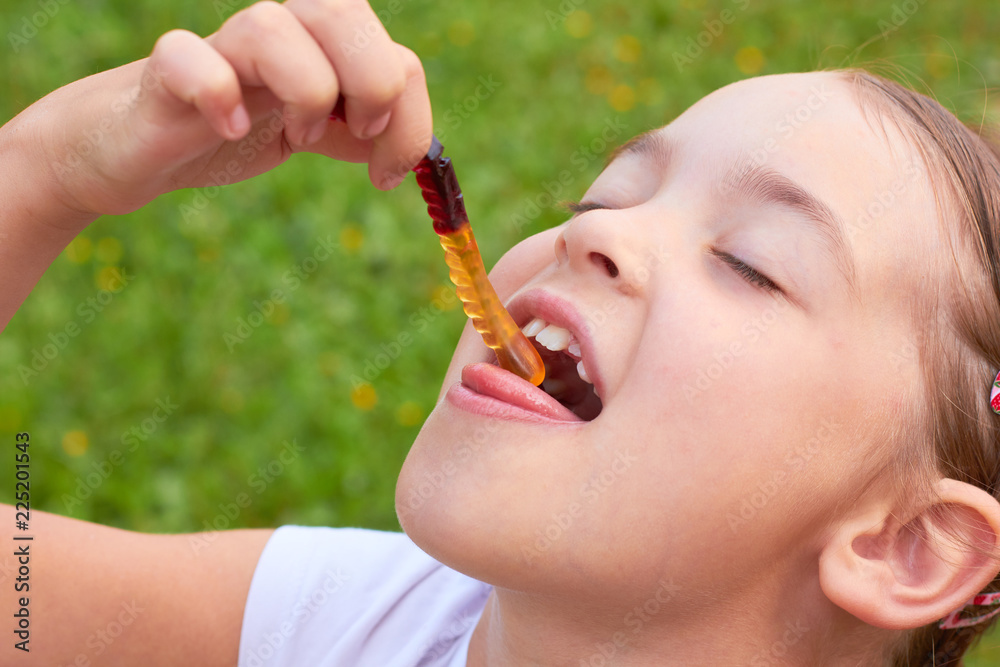 A child eats sweet jelly worms A child eats sweet jelly worms