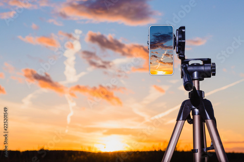 Obraz na płótnie Smartphone on tripod capturing image of sundown in vertical mode w salonie