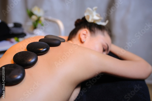 Stone therapy on a female client in beauty spa lateral view