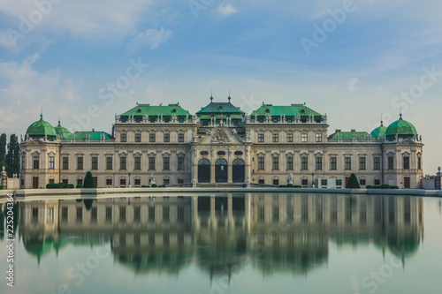 Full view of a baroque Upper Palace in historical complex Belvedere, Vienna, Austria with cloudy sky. It is a popular touristic attraction with famous museum and beautiful park with pond