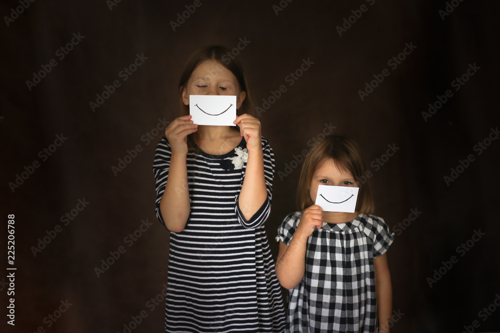 children siblings with smile and sadness on paper