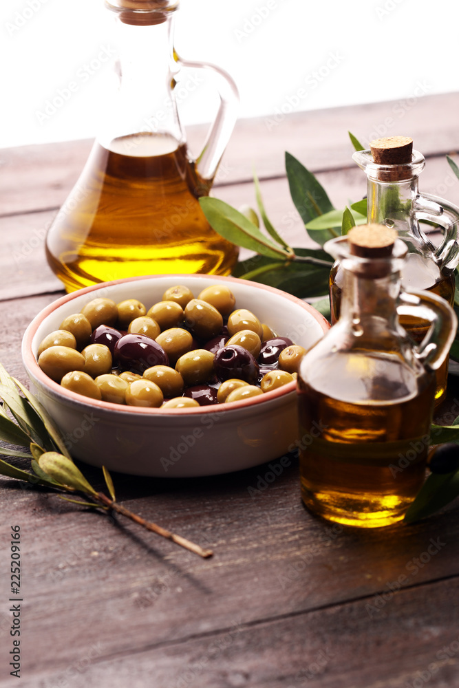 Olives. Bottle virgin olive oil and oil in a bowl with some olives Olives. Bottle virgin olive oil and oil in a bowl with some olives