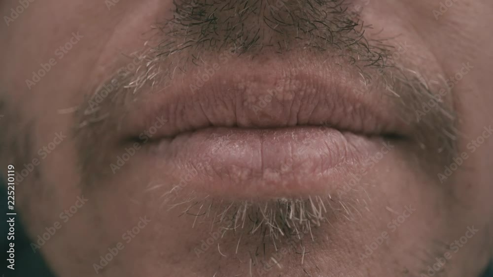 Close-up of the lips of a man with a beard who smiles Close-up of the lips of a man with a beard who smiles