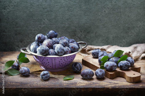fresh blue plums with leaves