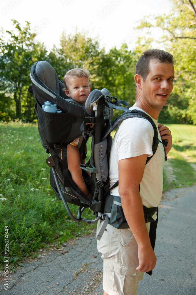 Father on a walk with kik in child carrier backpack Father on a walk with kik in child carrier backpack