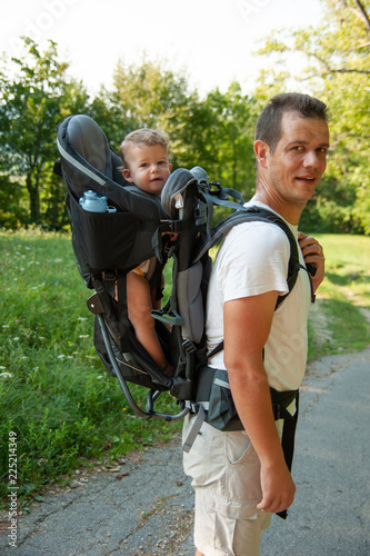 Father on a walk with kik in child carrier backpack