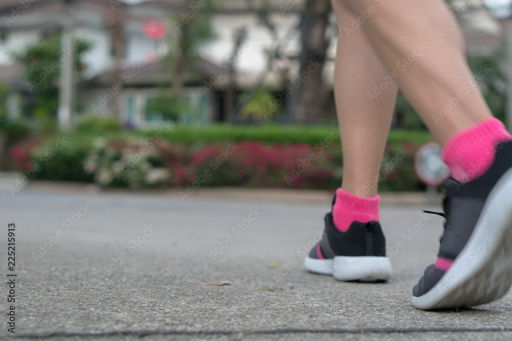 Blur: Young woman running on asphalt