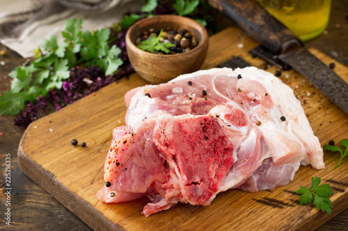 Fresh raw meat. Raw pork meat steak with olive oil, spices and herbs on wooden table. Copy space.