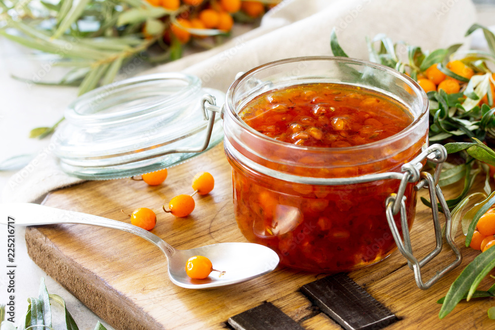 Homemade jam. Glass jar with sea buckthorn jam on rustic background. Preserved berry. Copy space. Homemade jam. Glass jar with sea buckthorn jam on rustic background. Preserved berry. Copy space.