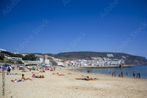 People on the beach with village on the background © raquel