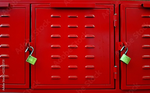 Closeup f red lockers doors and two brass padlocks.