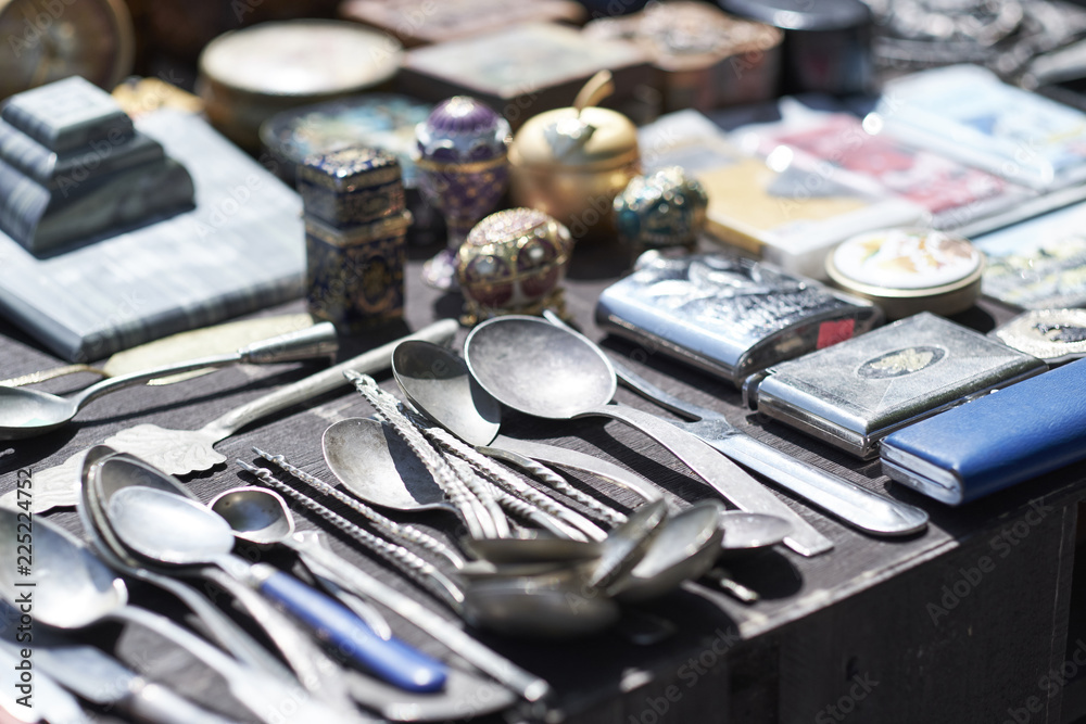 Fototapeta premium Market boot with objects beeing selled at the weekend flea market in the city center. Curious visitors in the background.