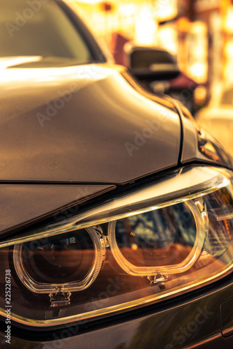 Headlights and hood of sport brown car