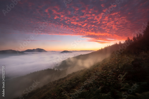 Colorful sunrise over Aramaiona valley under the fog in Alava