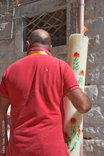 Bearer of large candle for the patronal feast. photo